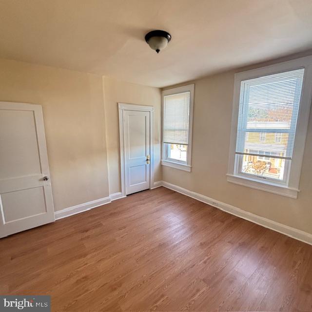 2891 Pelham Avenue Baltimore, MD 21213 - Photo 7 of 11 a view of an empty room with wooden floor and a window