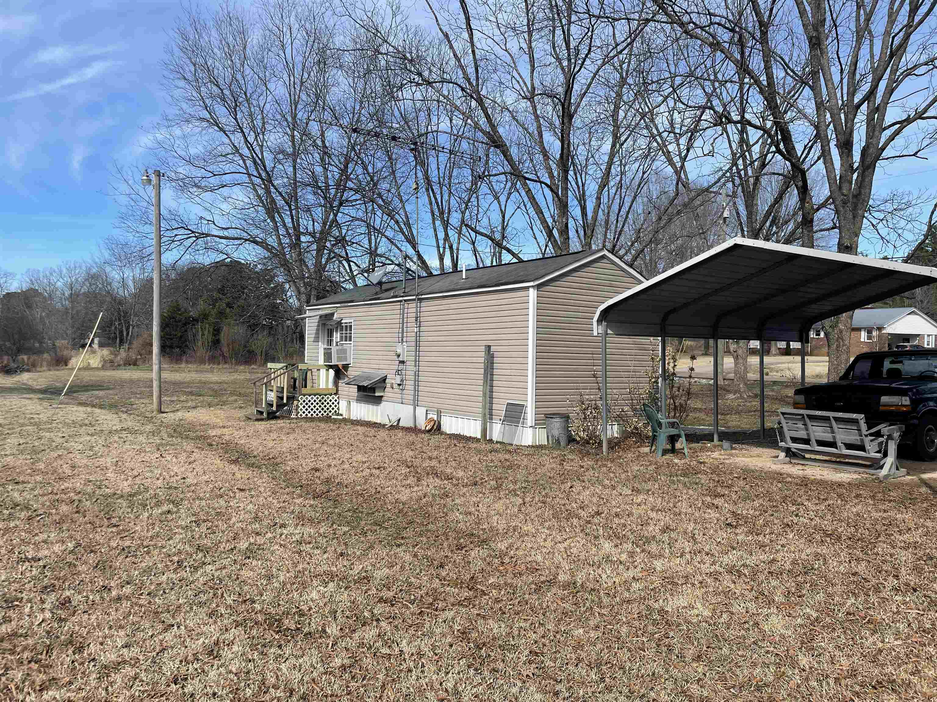 4130 Henderson Road Sardis, TN 38371 - Photo 13 of 14 a backyard of a house with table and chairs under an umbrella