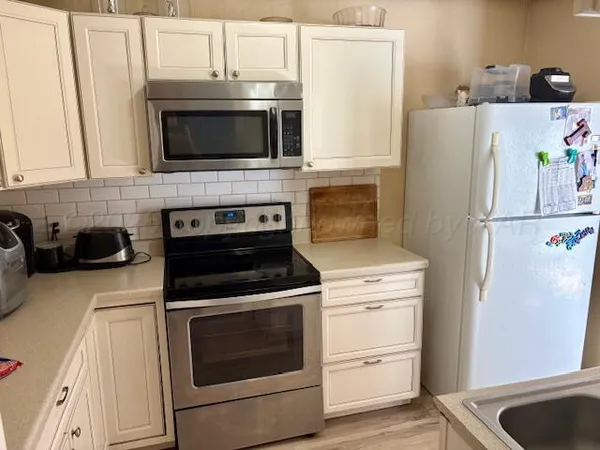 a kitchen with cabinets and steel stainless steel appliances