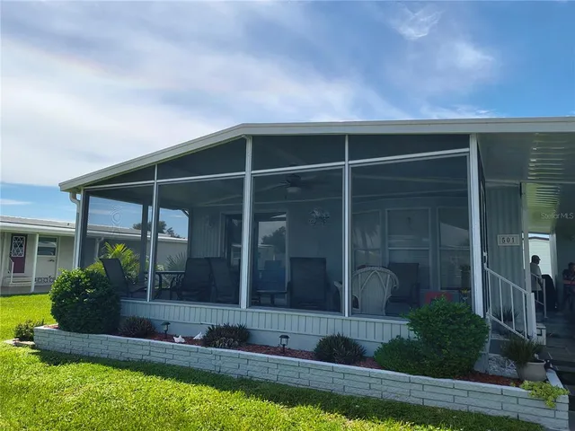 a view of house with backyard outdoor seating and hardwood floor