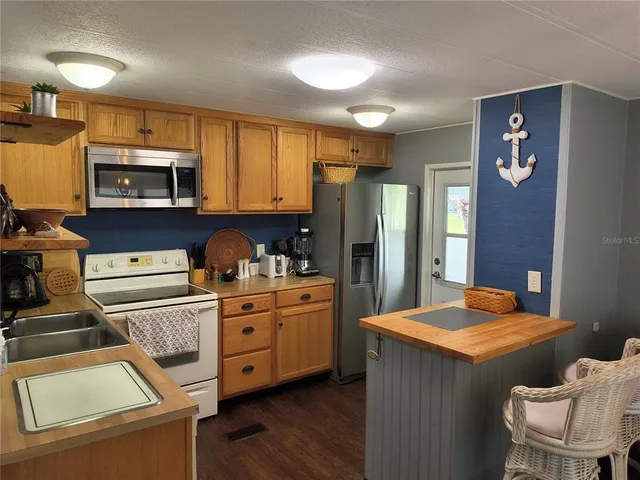 a kitchen with stainless steel appliances granite countertop a refrigerator a stove top oven a sink and dishwasher