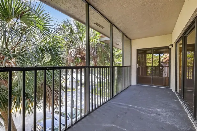 a view of a swimming pool with a lawn chairs under an umbrella