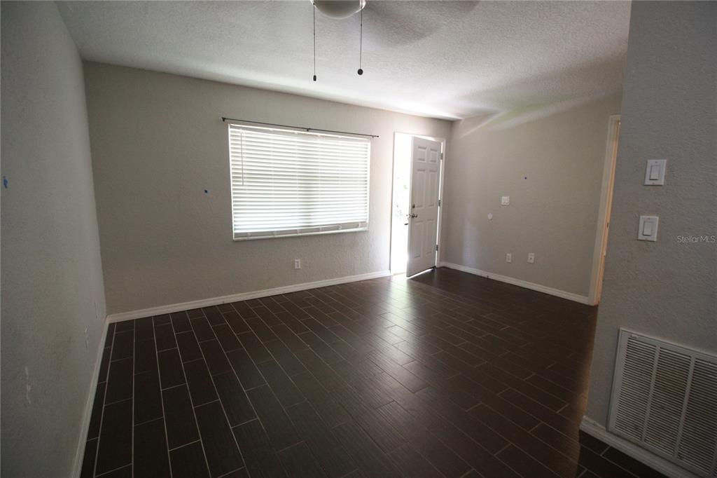 6101 Southeast Foss Road, Unit 4 Belleview, FL 34420 - Photo 13 of 19 an empty room with wooden floor cabinet and windows