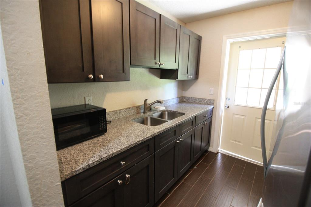 6101 Southeast Foss Road, Unit 4 Belleview, FL 34420 - Photo 2 of 19 a kitchen with stainless steel appliances granite countertop a sink a stove and a refrigerator