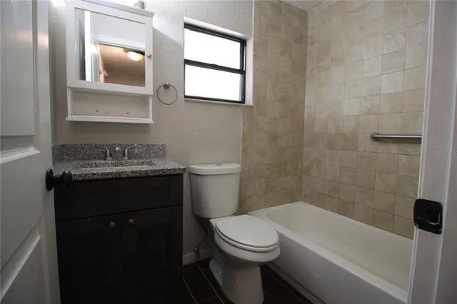 a bathroom with a granite countertop sink toilet and mirror