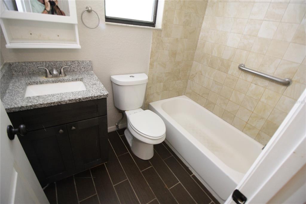 6101 Southeast Foss Road, Unit 4 Belleview, FL 34420 - Photo 9 of 19 a bathroom with a toilet a sink and bathtub