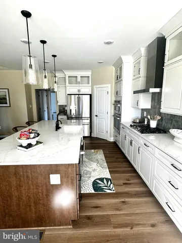 a kitchen with kitchen island granite countertop a sink stove and refrigerator