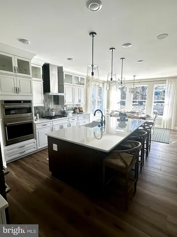 a kitchen with kitchen island granite countertop a sink cabinets and wooden floor