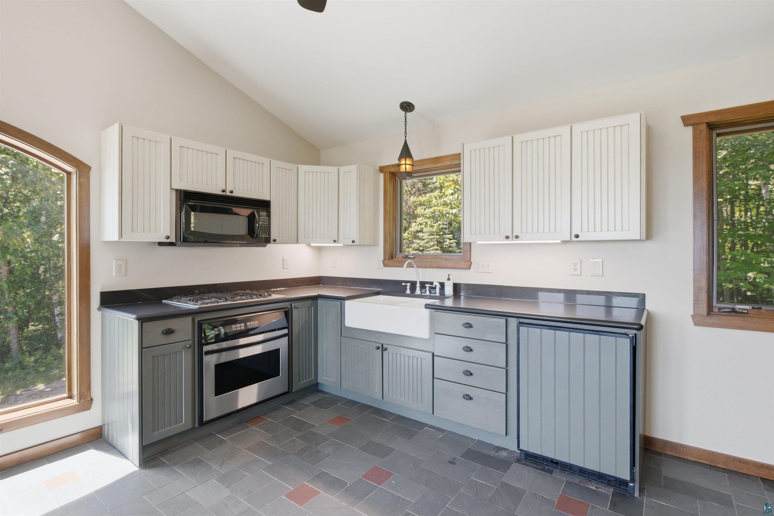 86270 Meyers-Olson Road Bayfield, WI 54814 - Photo 11 of 33 Kitchen featuring two-tone cabinetry, a stainless steel range and microwave, and a farmhouse sink