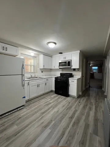 a kitchen with stainless steel appliances granite countertop a stove top oven a sink dishwasher and a refrigerator