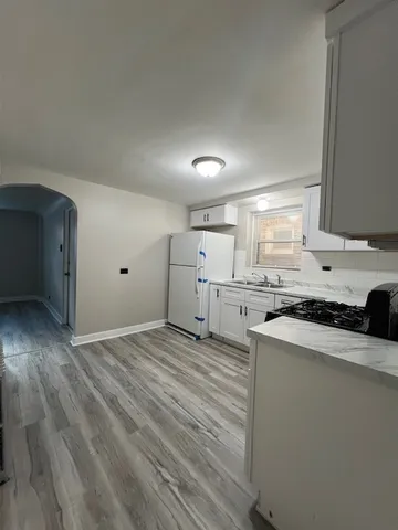 a kitchen with white cabinets and white appliances