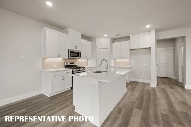 a kitchen with refrigerator and white cabinets