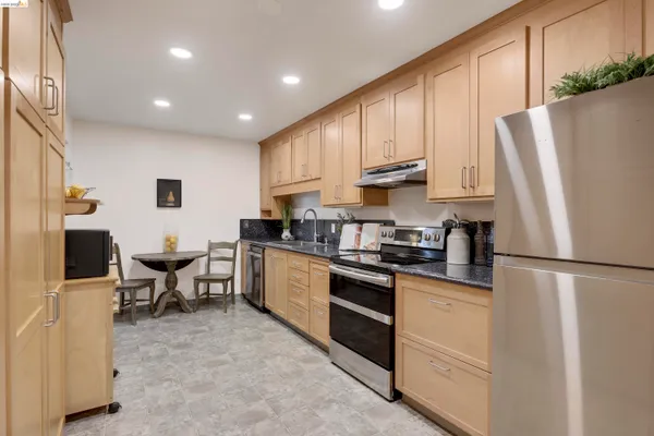 a kitchen with stainless steel appliances a refrigerator and a stove top oven