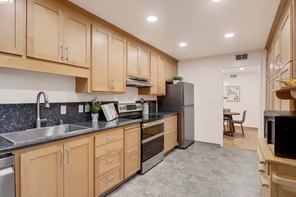 a kitchen with stainless steel appliances granite countertop a refrigerator and a stove