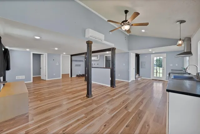 an aerial view of residential houses with outdoor space and trees