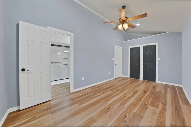wooden floor in an empty room with a chandelier fan
