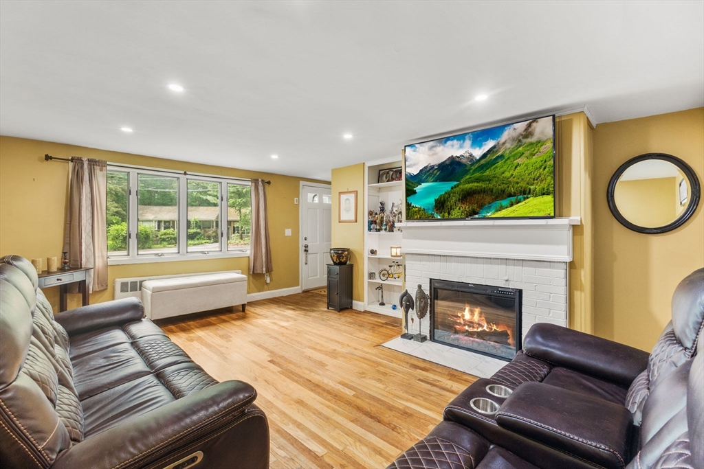 28 Maple Circle Randolph, MA 02368 - Photo 5 of 24 a living room with furniture a fireplace and a large window