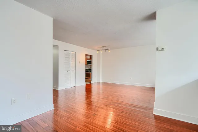 a view of an empty room with wooden floor
