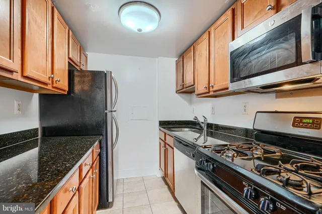 a kitchen with stainless steel appliances granite countertop a stove and a microwave