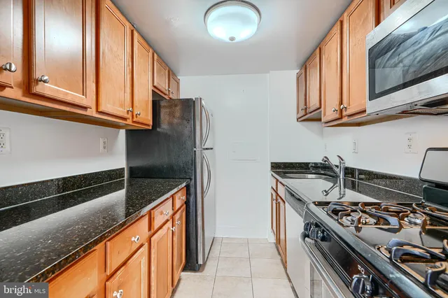 a kitchen with stainless steel appliances granite countertop a stove and a microwave