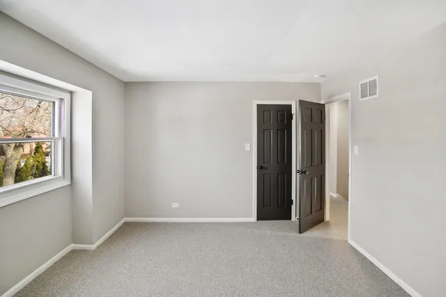 an empty room with windows and closet