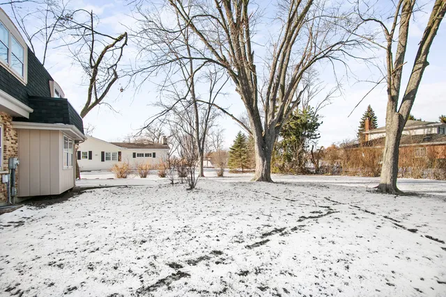 a view of a yard covered with snow in the front of house