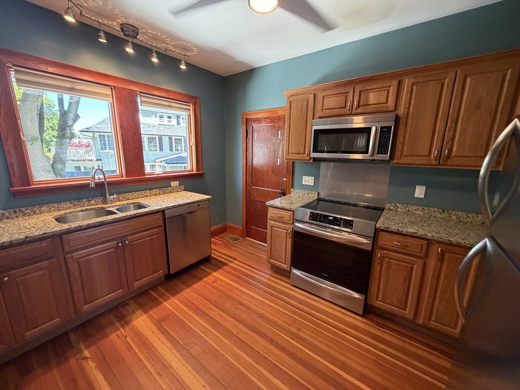 12-14 Warwick Road, Unit 12 Belmont, MA 02478 - Photo 3 of 15 a kitchen with stainless steel appliances granite countertop a sink stove and microwave