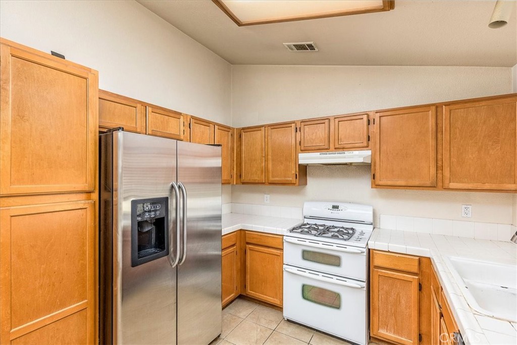 43115 Corte Landeros Temecula, CA 92592 - Photo 11 of 42 a kitchen with a refrigerator sink and stove top oven
