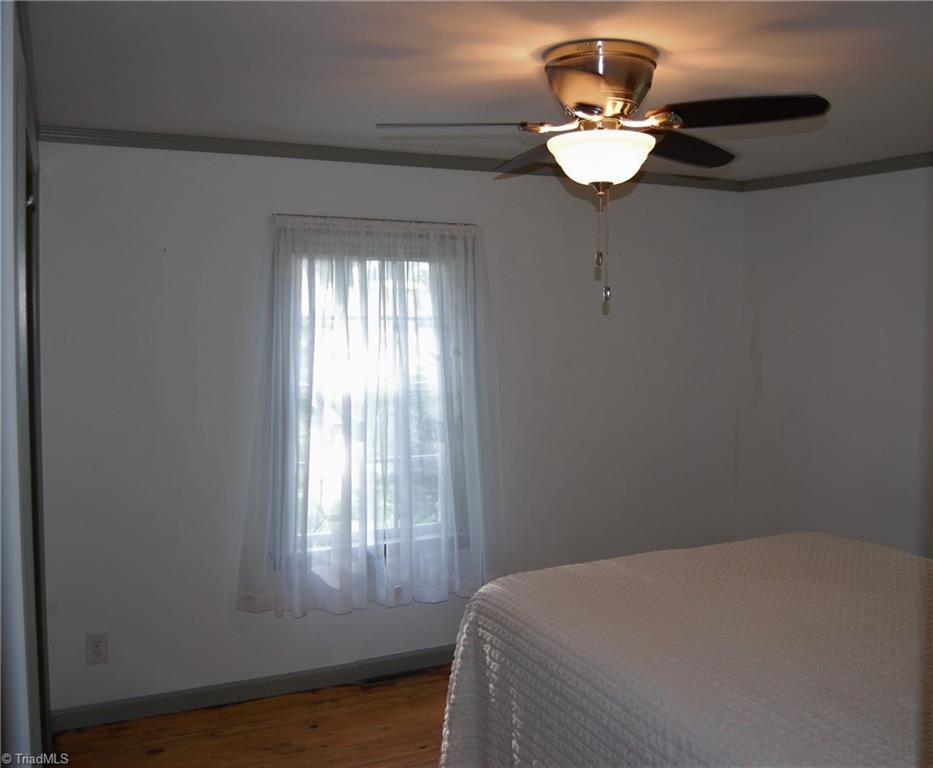 1395 Smothers Road Madison, NC 27025 - Photo 13 of 25 Bedroom number two, a wonderful space with a nice closet and ceiling fan.