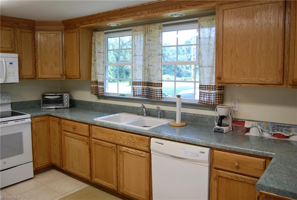 1395 Smothers Road Madison, NC 27025 - Photo 19 of 25 Large double windows in front of the sink add lots of natural light to the large updated kitchen.
