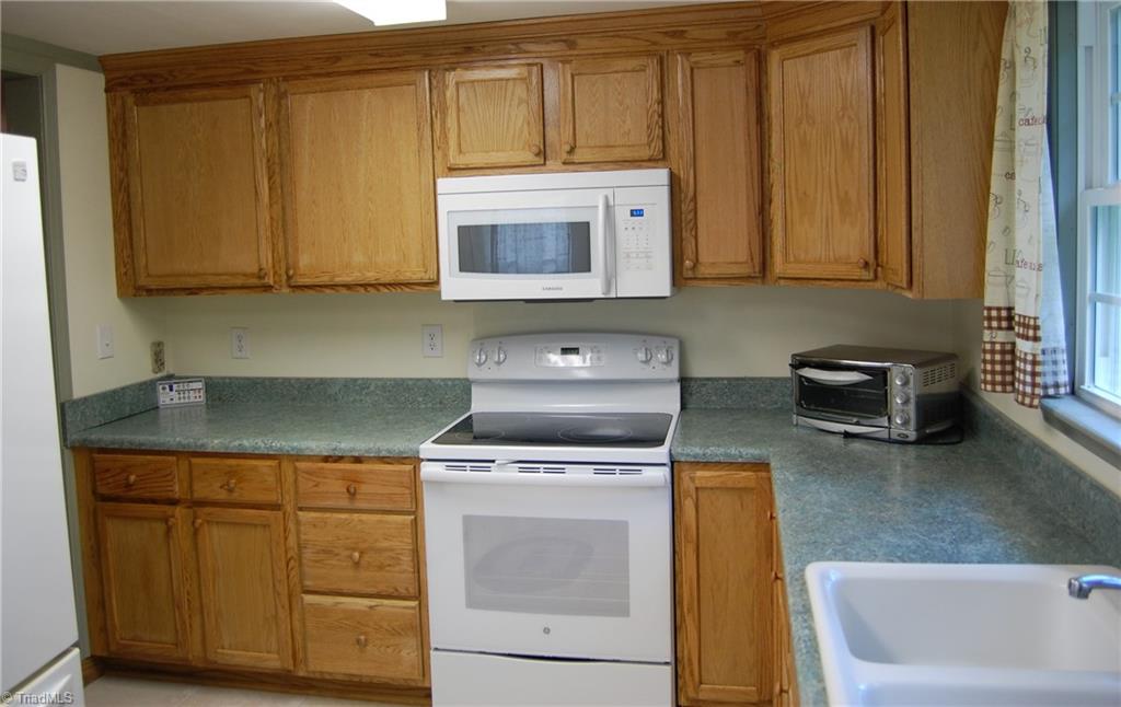1395 Smothers Road Madison, NC 27025 - Photo 20 of 25 The updated kitchen features a solid surface electric range and built in microwave. The large storage cabinets feature plenty of room to store all your kitchen gadgets.