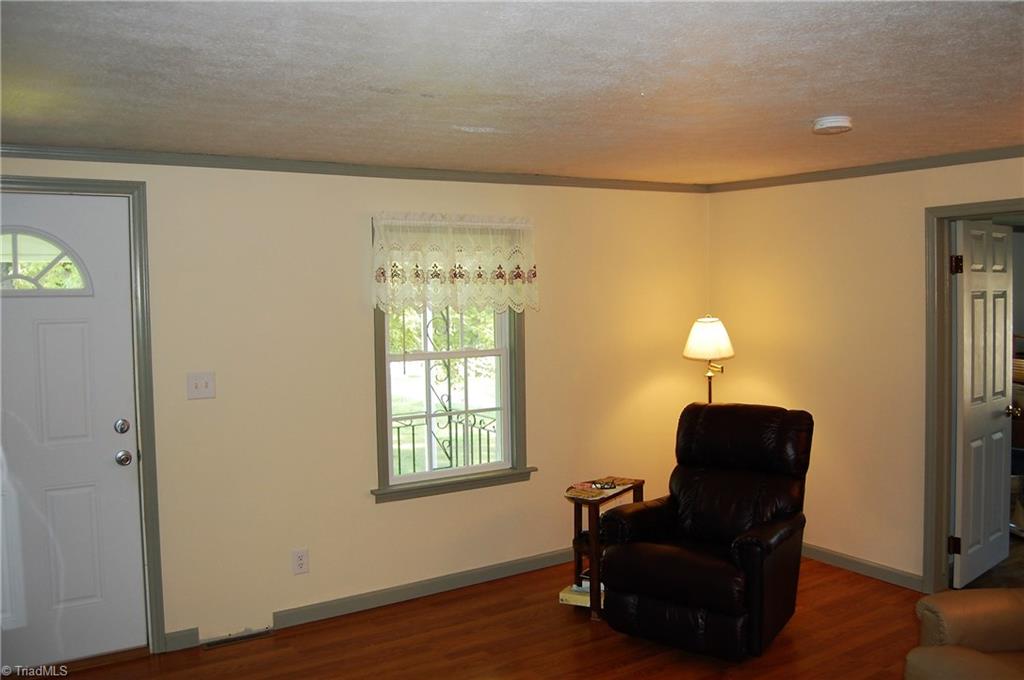 1395 Smothers Road Madison, NC 27025 - Photo 9 of 25 Enjoy the spacious living room with updated laminate floors.