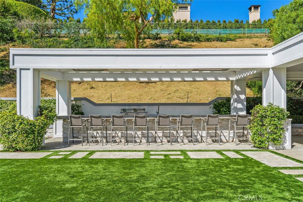 4 Inverness Lane Newport Beach, CA 92660 - Photo 41 of 56 a view of a swimming pool with a lawn chairs and potted plants