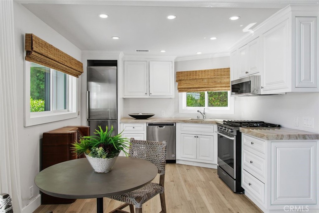 4 Inverness Lane Newport Beach, CA 92660 - Photo 47 of 56 a kitchen with stainless steel appliances a kitchen island hardwood floor sink stove and dining table