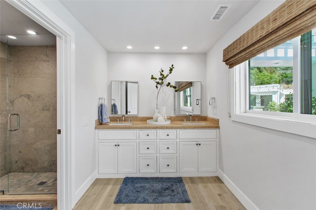4 Inverness Lane Newport Beach, CA 92660 - Photo 48 of 56 a spacious bathroom with a granite countertop sink a mirror and a shower