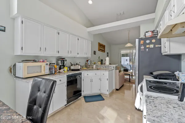 a kitchen with granite countertop a sink stove and cabinets