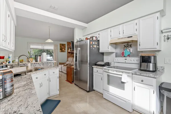 a kitchen with stainless steel appliances granite countertop a stove refrigerator and cabinets