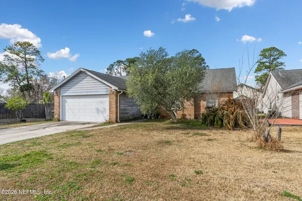 a view of a house with a yard and tree