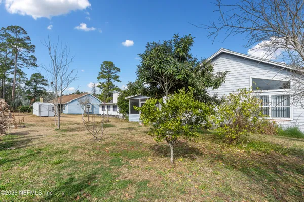 a front view of a house with a yard and trees