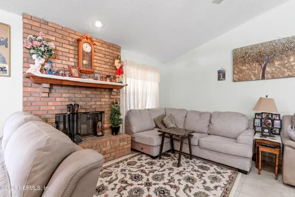 a living room with furniture a fireplace and window