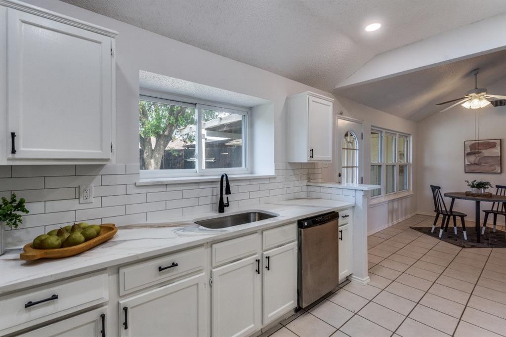 1509 Clover Drive Allen, TX 75002 - Photo 19 of 25 a kitchen with granite countertop a sink a stove and cabinets