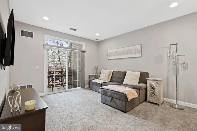 a living room with furniture a flat screen tv and a window
