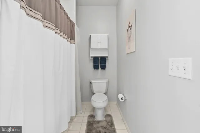 a bathroom with a toilet and a shower curtain