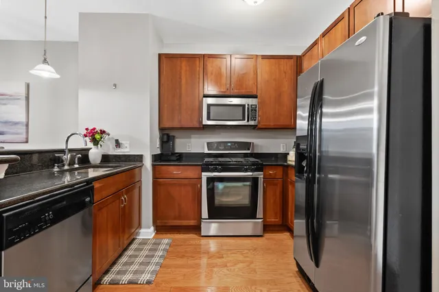 a kitchen with stainless steel appliances granite countertop a sink stove and refrigerator