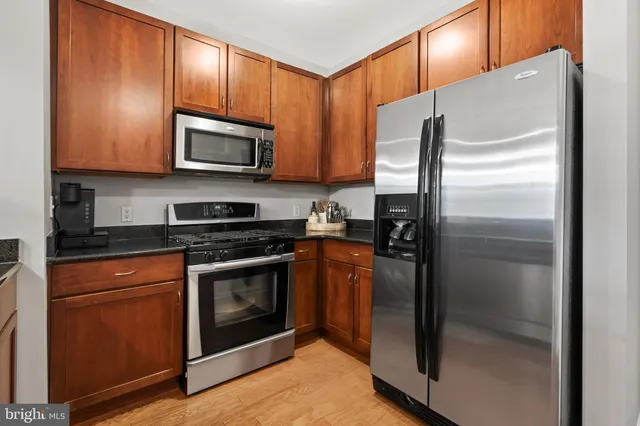 a kitchen with stainless steel appliances granite countertop a refrigerator stove and microwave