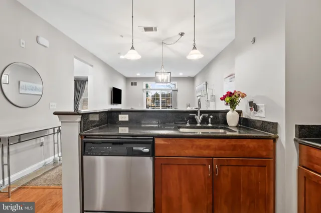 a kitchen with stainless steel appliances granite countertop a sink and a refrigerator