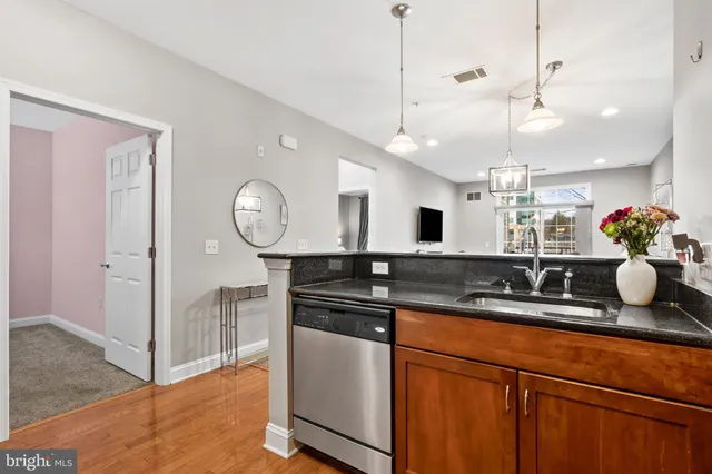 a kitchen with kitchen island granite countertop a sink a counter and cabinets