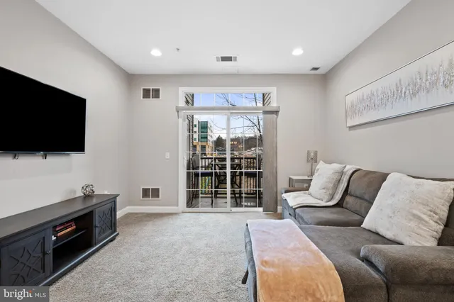 a living room with furniture a flat screen tv and a window