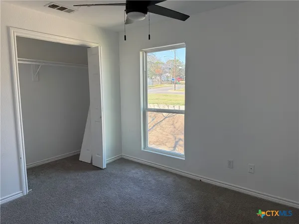 an empty room with windows and closet