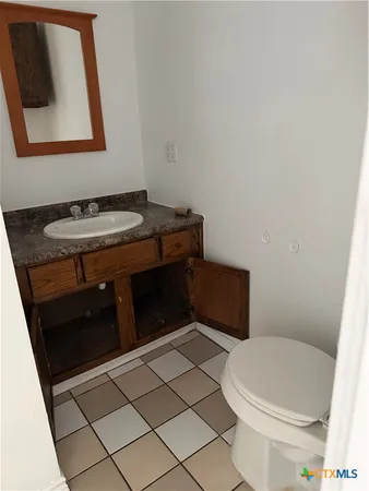 a bathroom with a toilet a sink and mirror